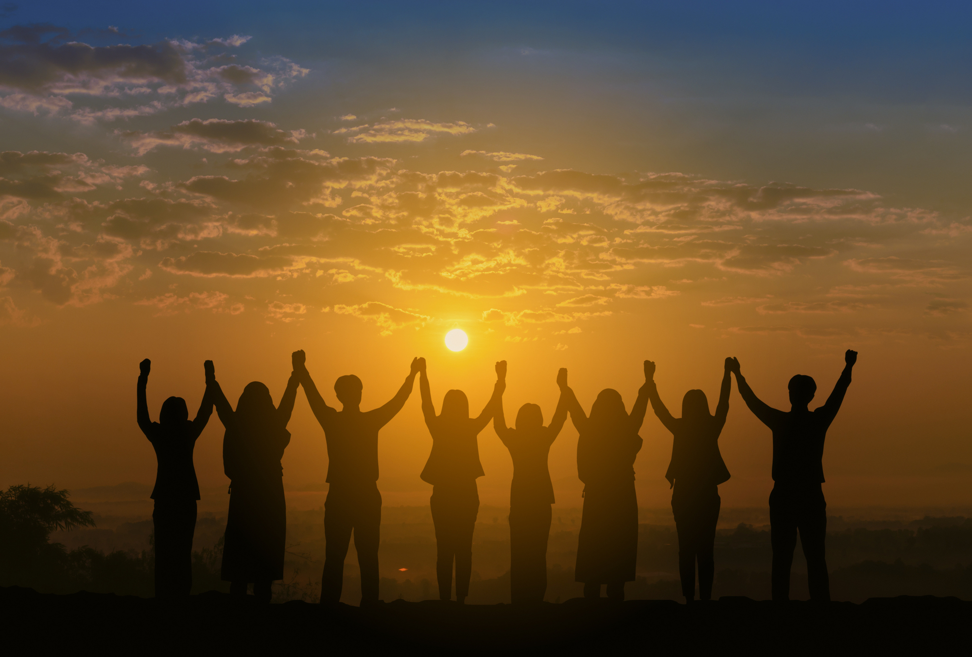 Silhouette of friends holding hands at sunrise, symbolizing unity, growth, and the art of friendship.